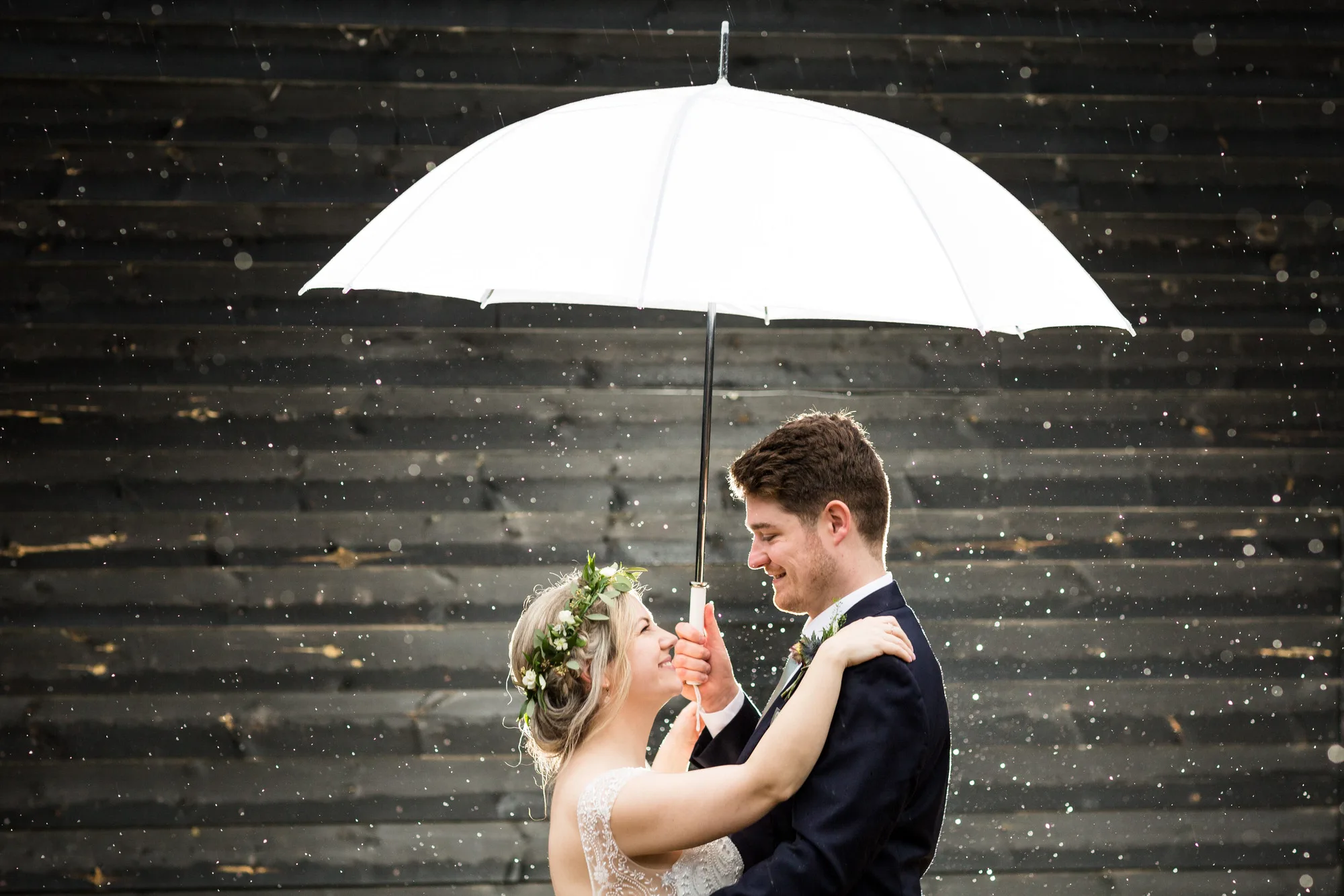 Professional Wedding Photography - bride and groom in the rain at their barn wedding in East Sussex.