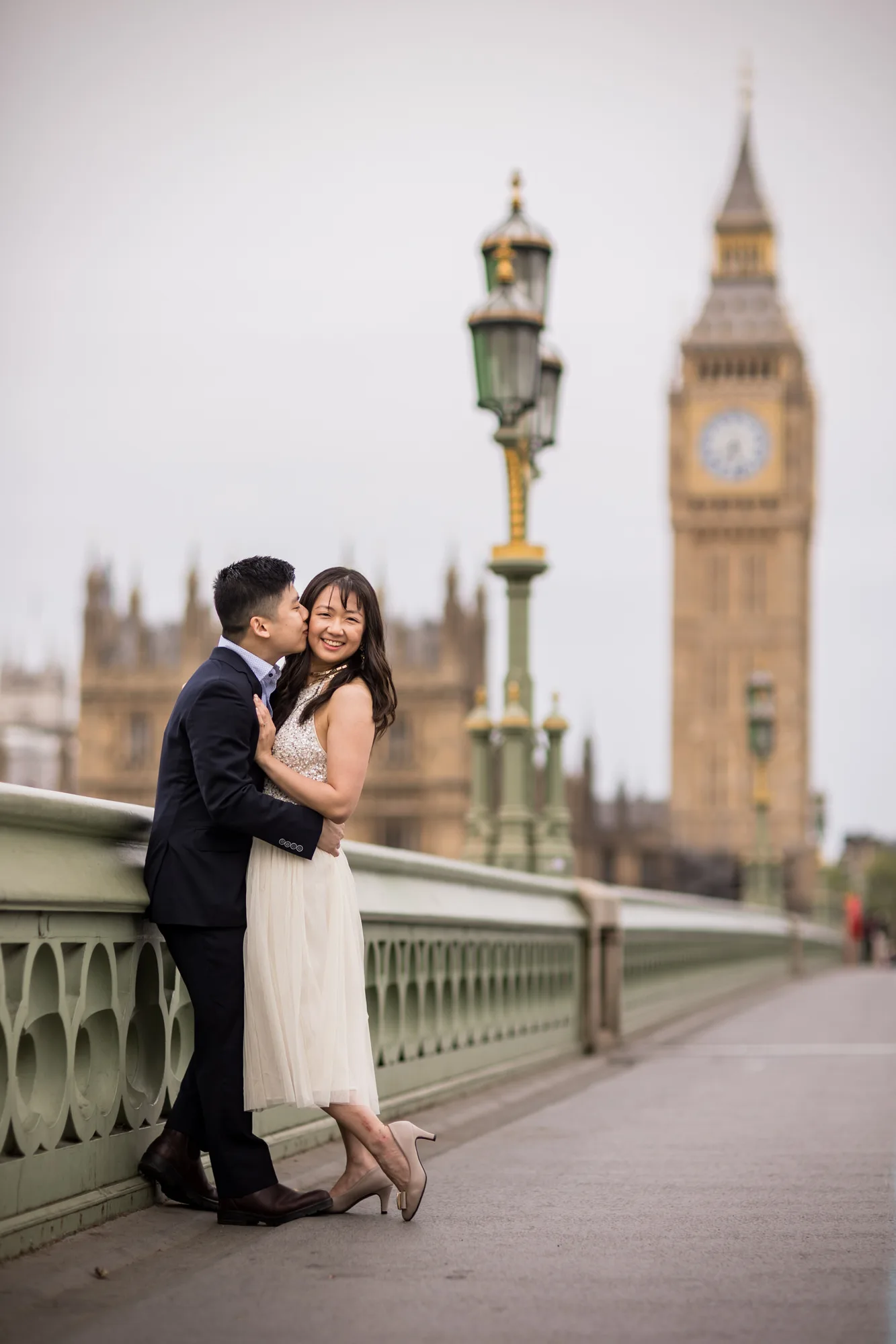 Reportage Wedding Photographer - a bride and groom enjoying their photo shoot on Westminster Bridge with the houses of Parliament in the background in London.
