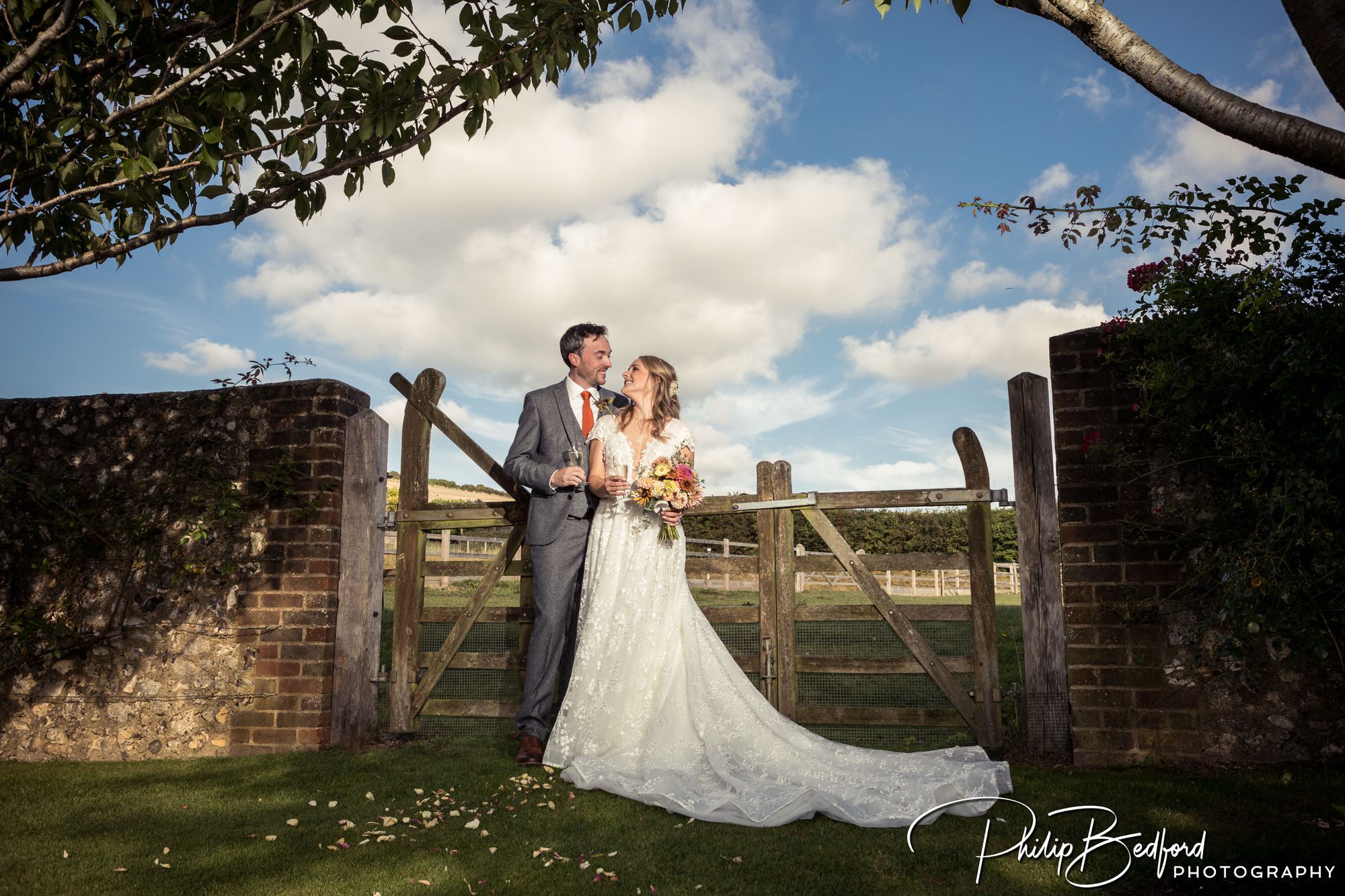 The bride and groom in front of a country side gate at A Pangdean Barn Wedding