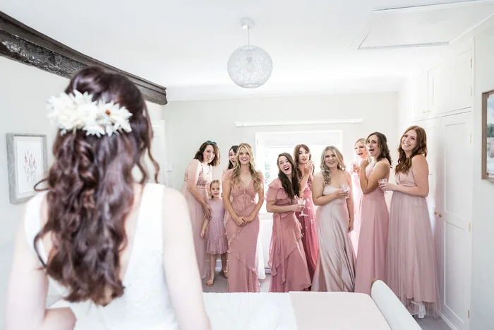 Sussex Wedding Photographer - bridesmaids see the bride for the first time in her dress